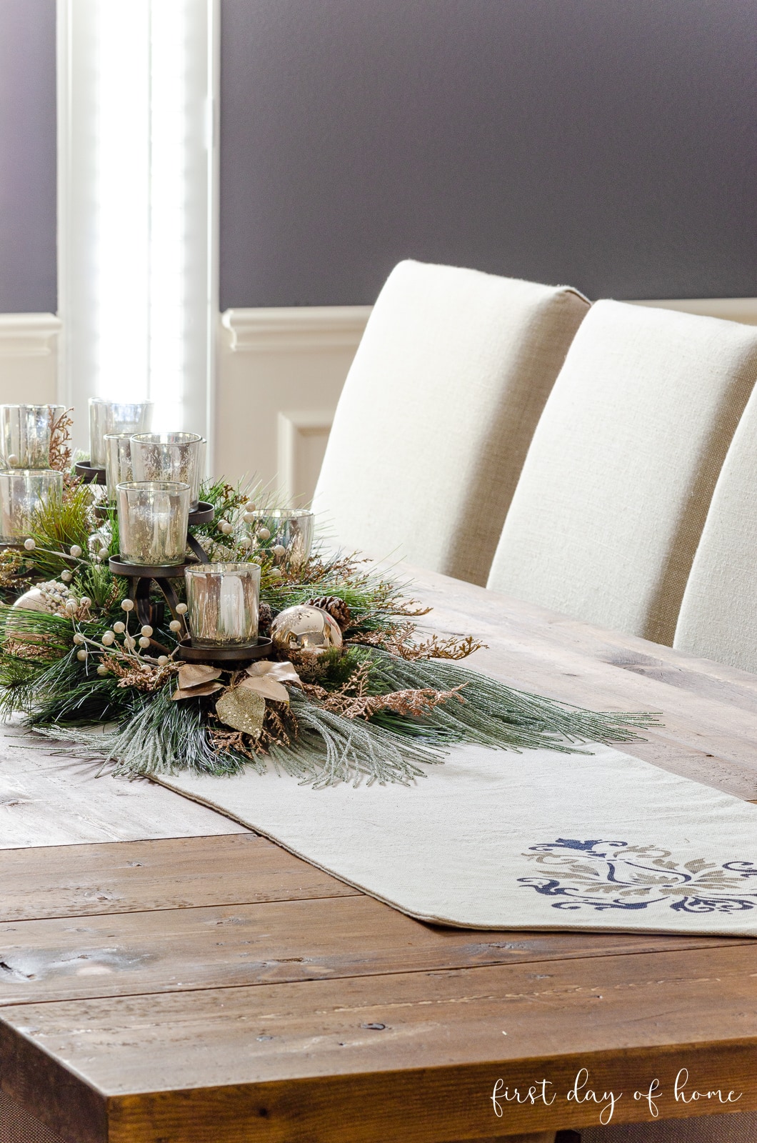 Mercury glass DIY holiday centerpiece on dining room table with table runner underneath.