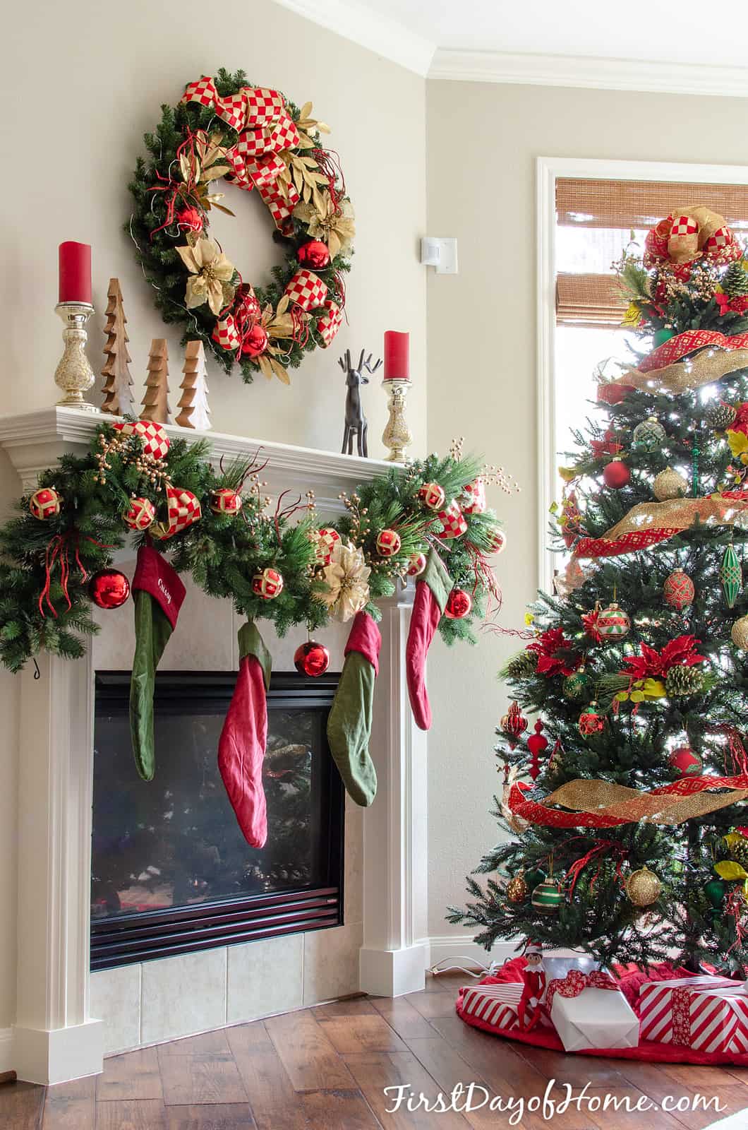 Christmas wreath and mantel by Christmas tree, decorated with red and gold.