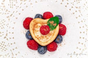 Heart shaped mini cheesecake with raspberries and blueberries