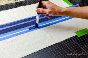 Painting navy stripes on DIY flour sack dish towels made of drop cloth