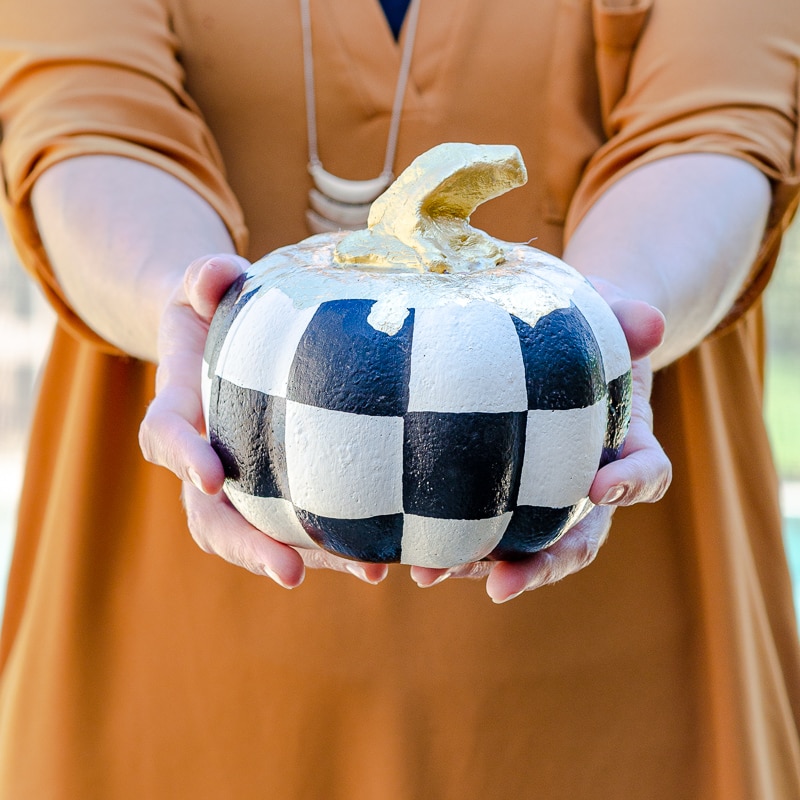 Painted foam pumpkin from dollar tree with black and white checkered theme and gold leaf stem