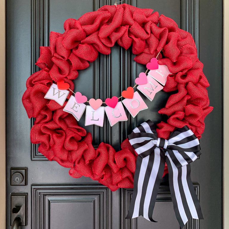 Red burlap wreath with bunting and striped black and white bow