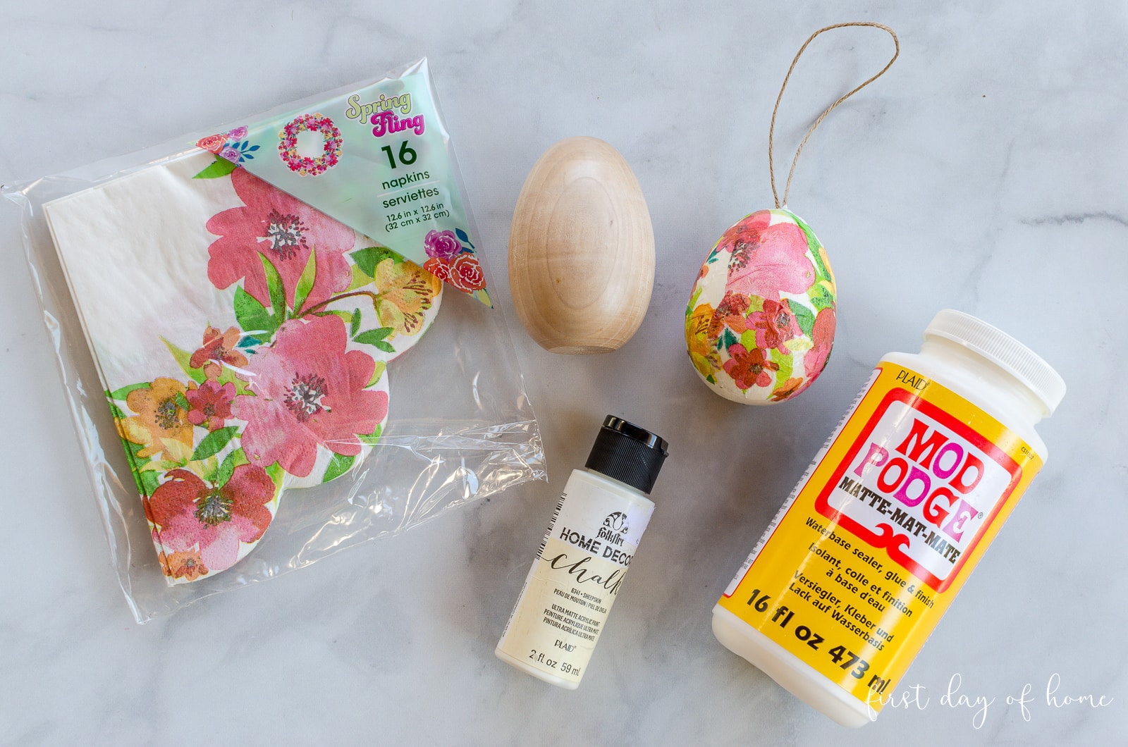Supplies for decoupage Easter eggs, including Mod Podge, napkins, paint and wooden eggs
