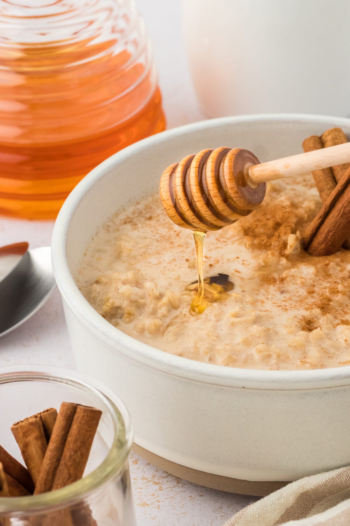 Sweetening Mexican oatmeal recipe with honey dipper.