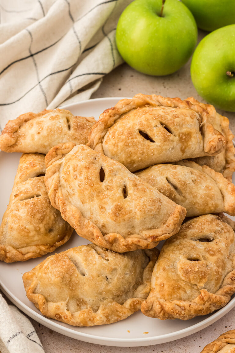 Apple empanadas on plate with green apples in the background