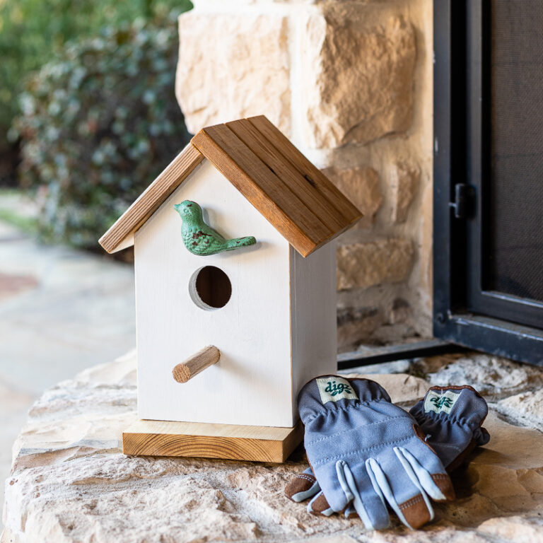 Birdhouse on outdoor patio with gardening gloves