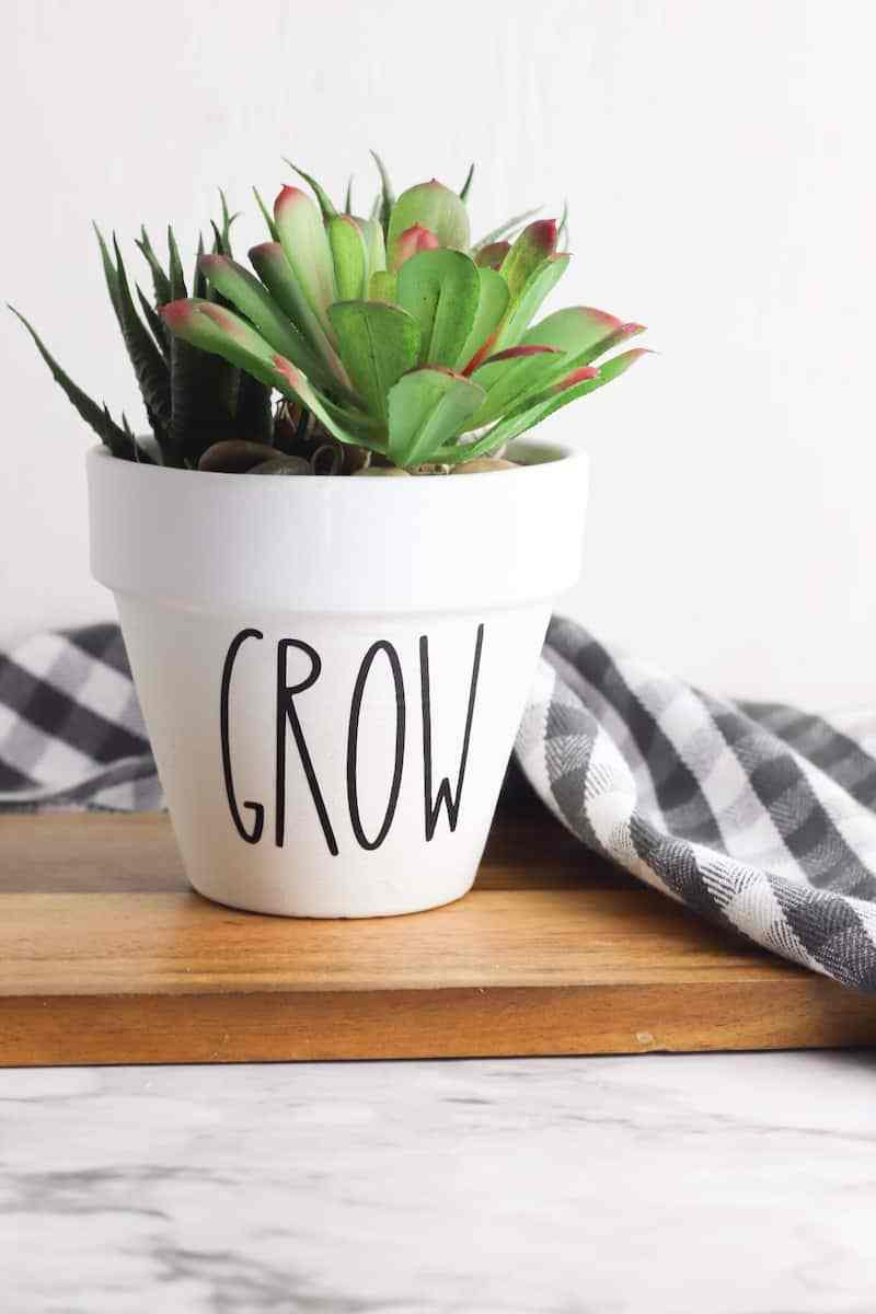 Rae Dunn inspired flower pot with white paint and black letters reading "Grow"