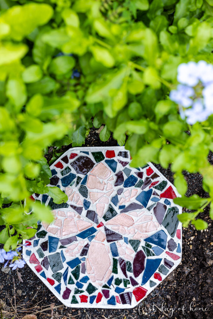 Mosaic stepping stone sitting on ground.
