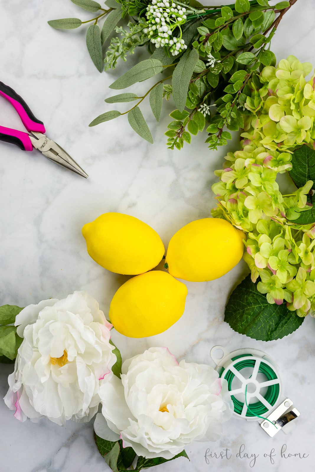 DIY wreath supplies, including faux lemons, hydrangeas, and greenery