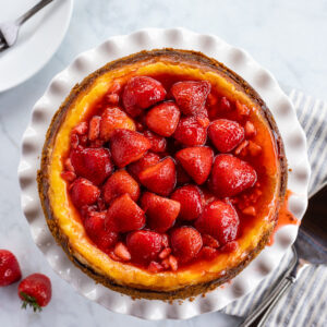 Strawberry cheesecake topped with strawberry halves in syrup