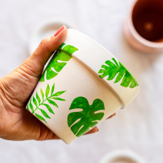 Stenciled flower pots with white base coat and green monstera leaf stencils