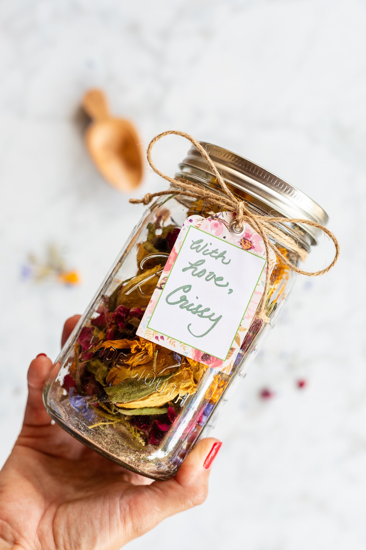 Homemade potpourri packaged as a gift in a mason jar with a gift tag.