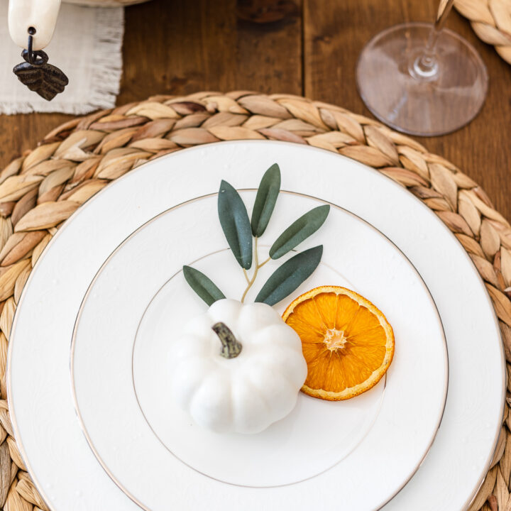 Place setting with faux pumpkin, olive stem and dried orange slice