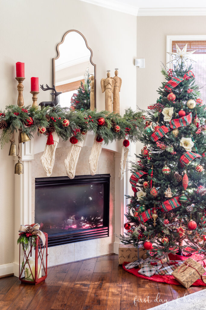 Christmas living room decor including Christmas tree and fireplace mantel with garland and Christmas accents