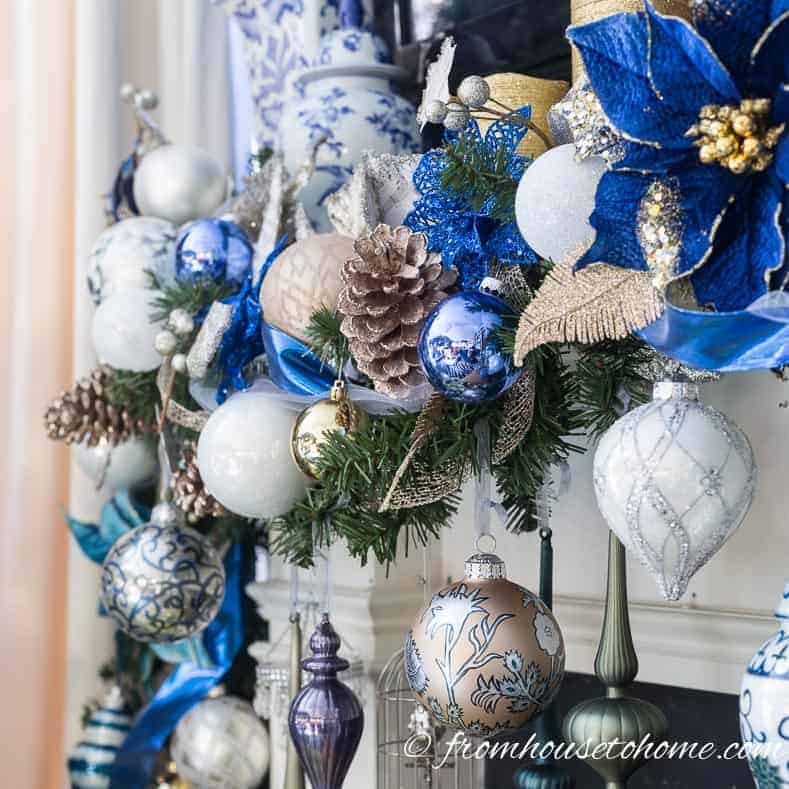 Christmas mantel with evergreen garland decorated with a blue and white color scheme
