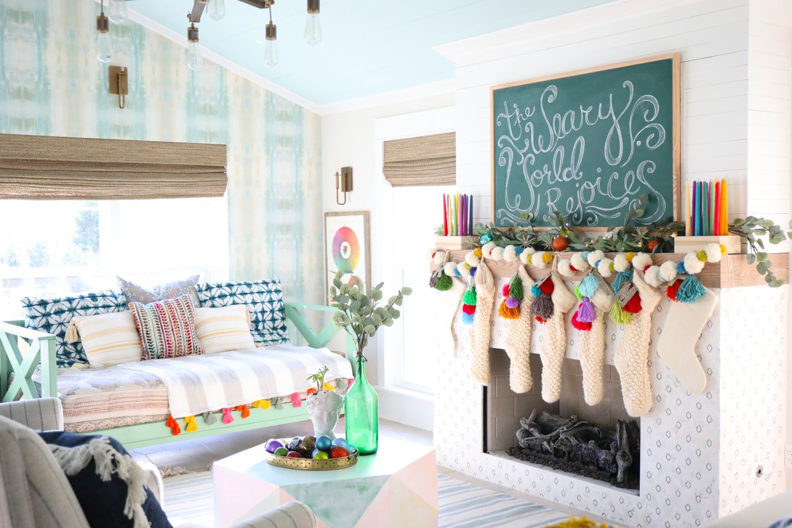 Christmas mantel with chalkboard sign and colorful stockings