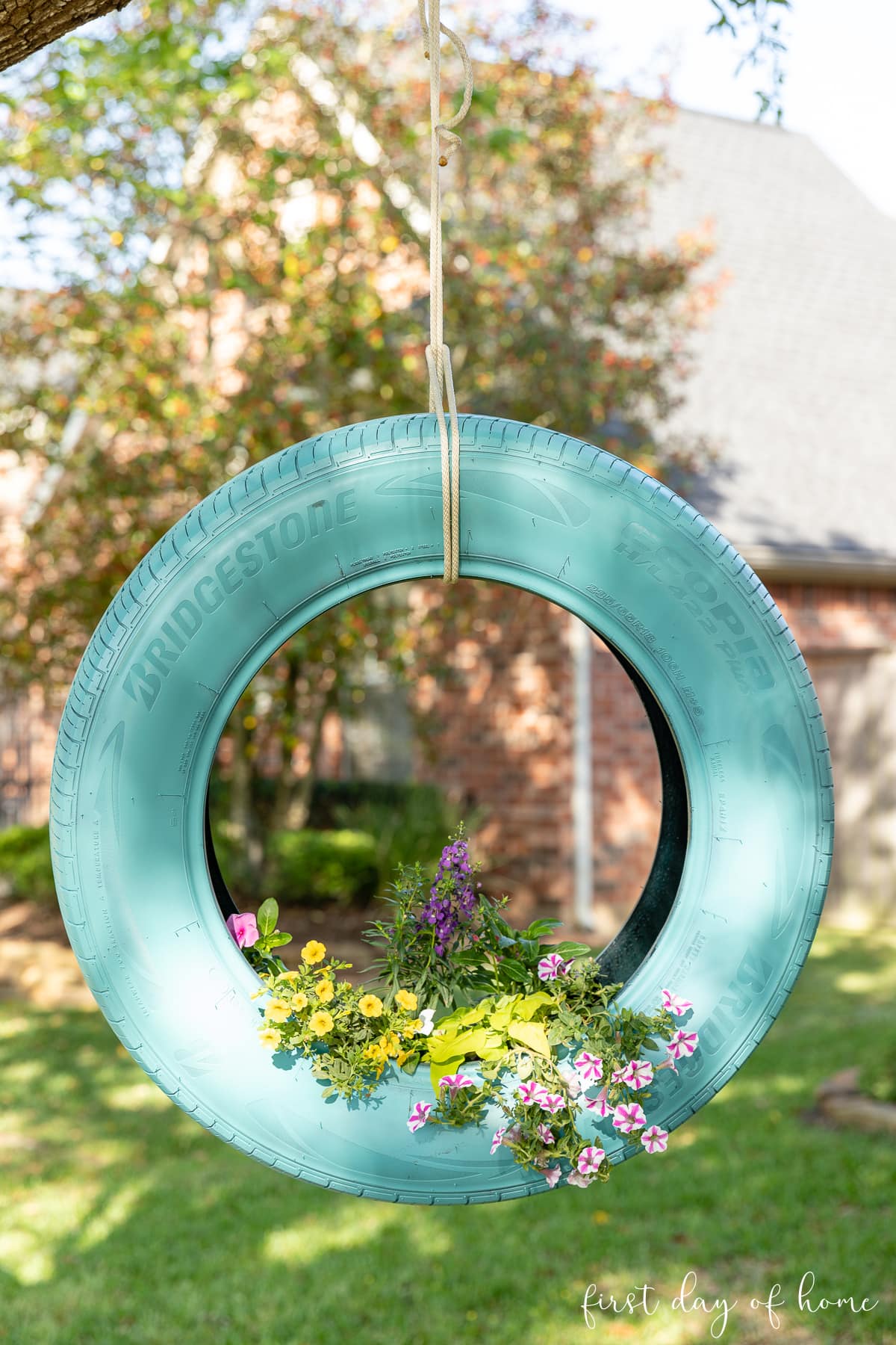 Hanging tire planter filled with mixed container flowers