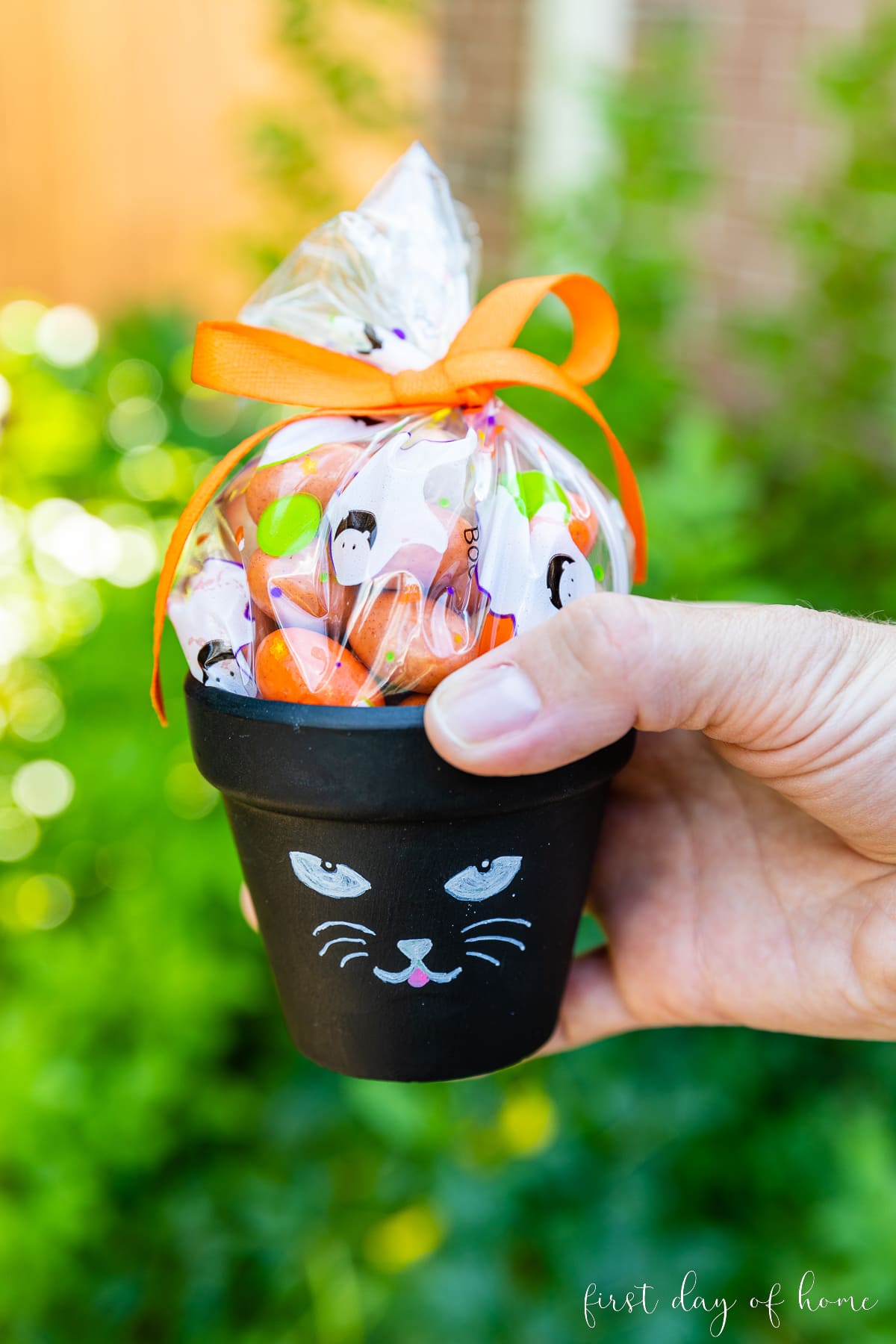 Flower pot painted like a black cat, filled with Halloween candy
