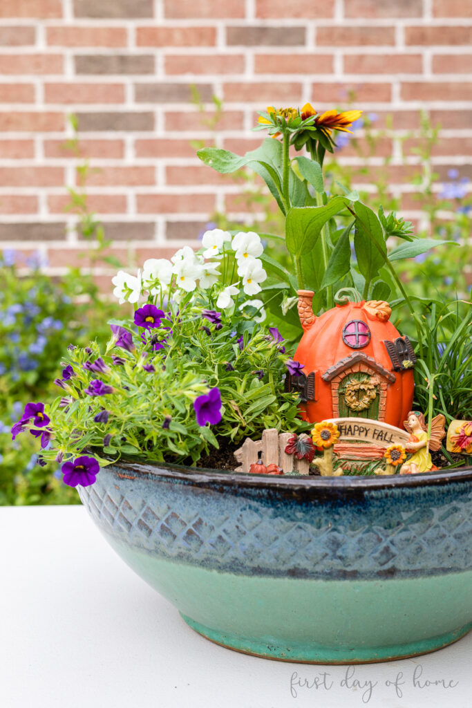 Fall fairy garden with Rudbeckia, Violas, Calibrachoa and figurines from Dollar Tree