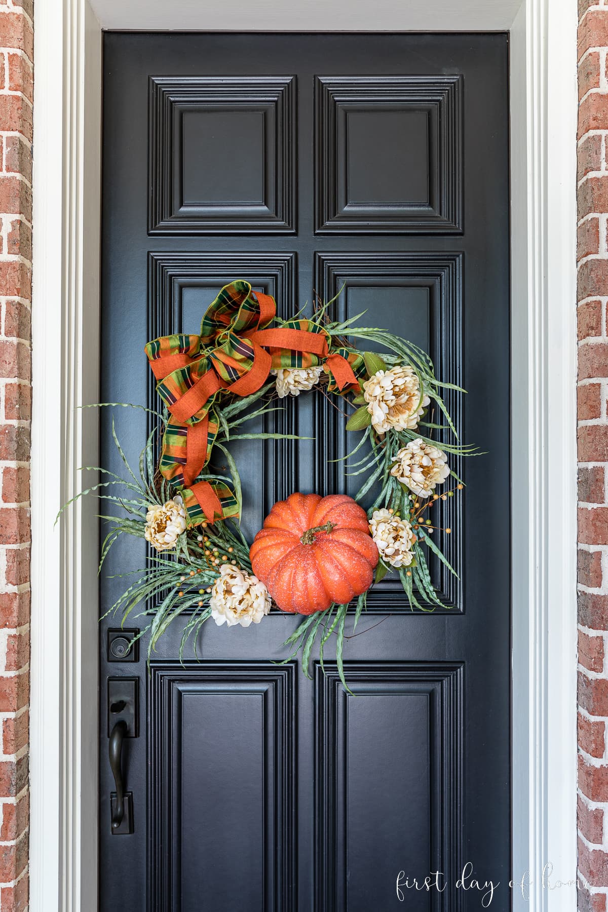 Closeup view of DIY fall grapevine wreath on front door.