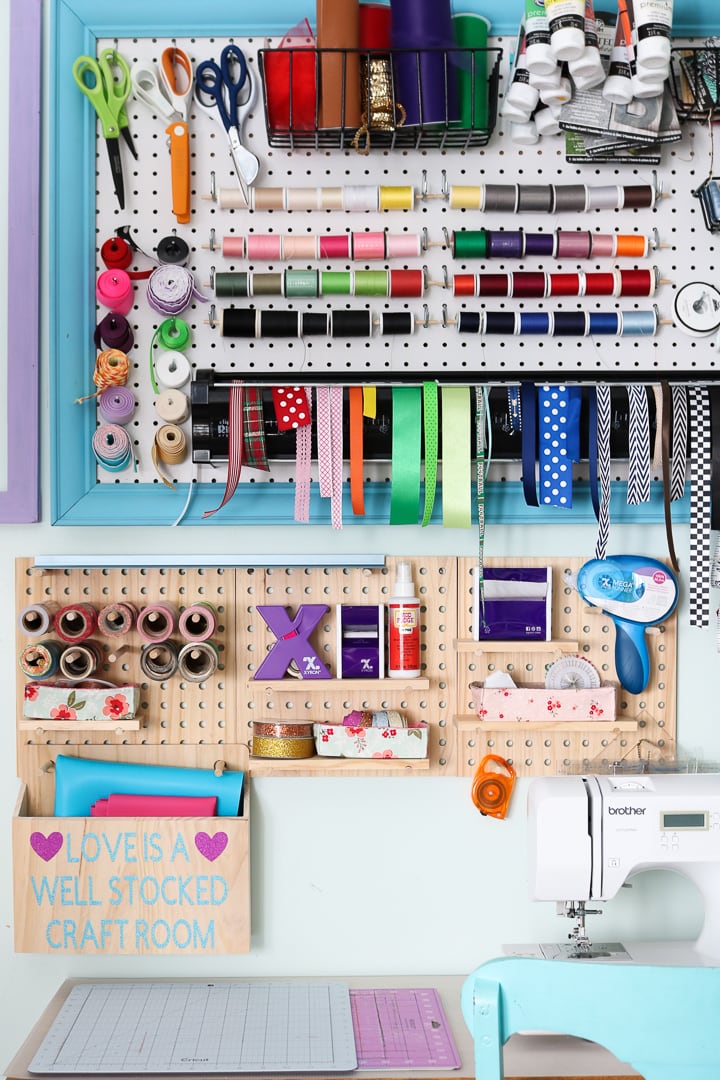 Colorful framed pegboards with racks for sewing notions and Cricut craft supplies