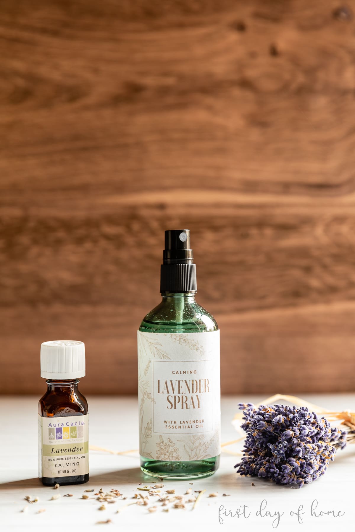 DIY lavender spray next to lavender essential oil and dried lavender stems