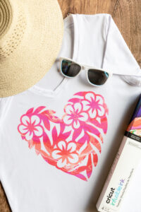 Infusible ink t-shirt with heart design made with Cricut infusible ink, shown with straw hat and sunglasses