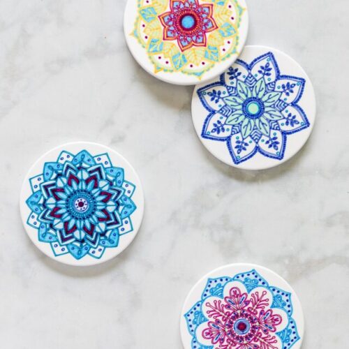 Four Cricut infusible ink coasters with mandala designs