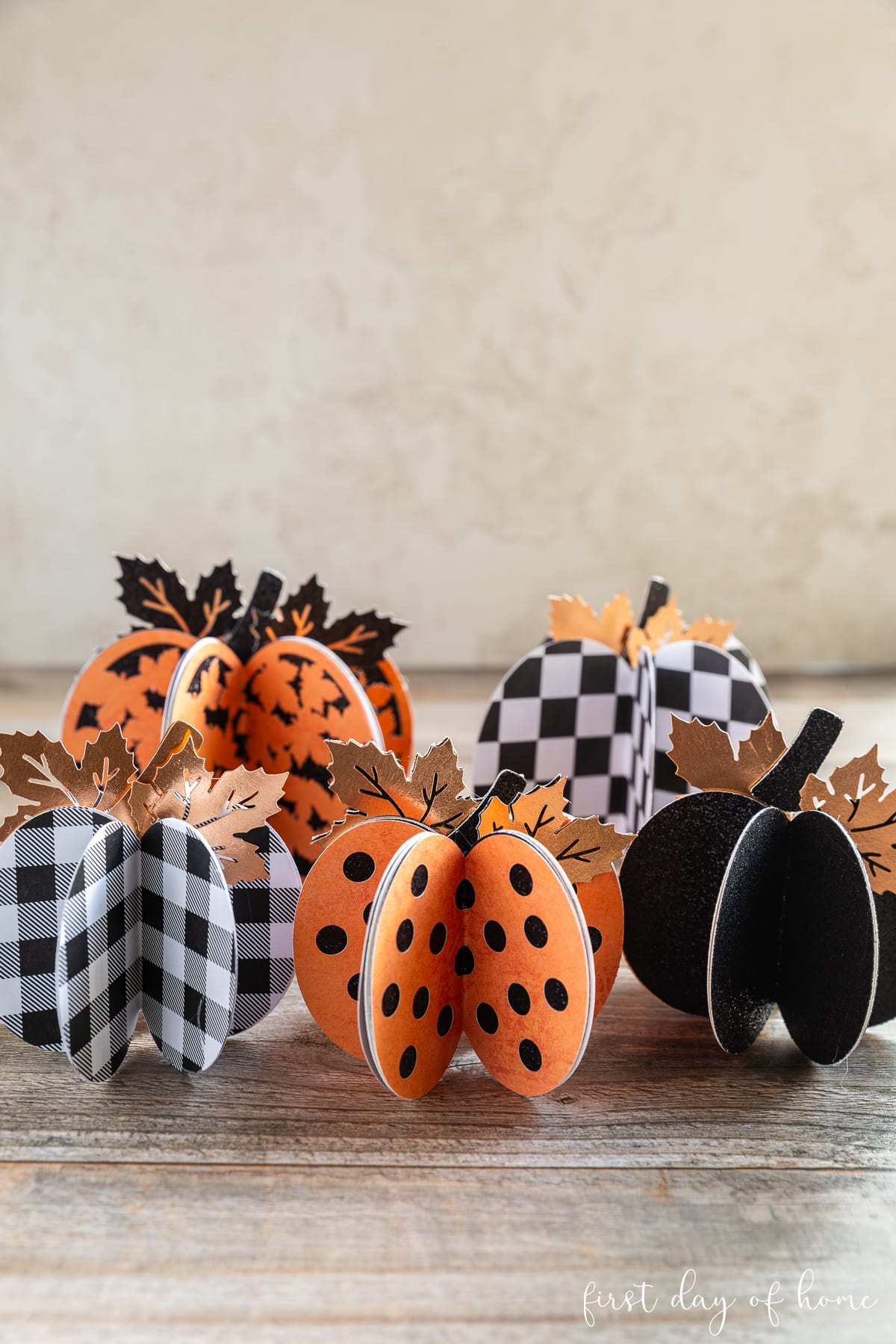 Five 3D paper pumpkins with Halloween themed patterns and colors