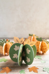 Paper pumpkins shown with mini paper leaves
