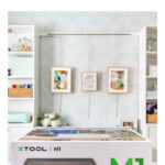 xTool M1 in craft room. Text overlay reads "Buyer's Guide xTool M1 Laser Cutter"