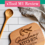 Wooden cutting board with text overlay reading "Should you buy a laser cutter? xTool M1 Review"