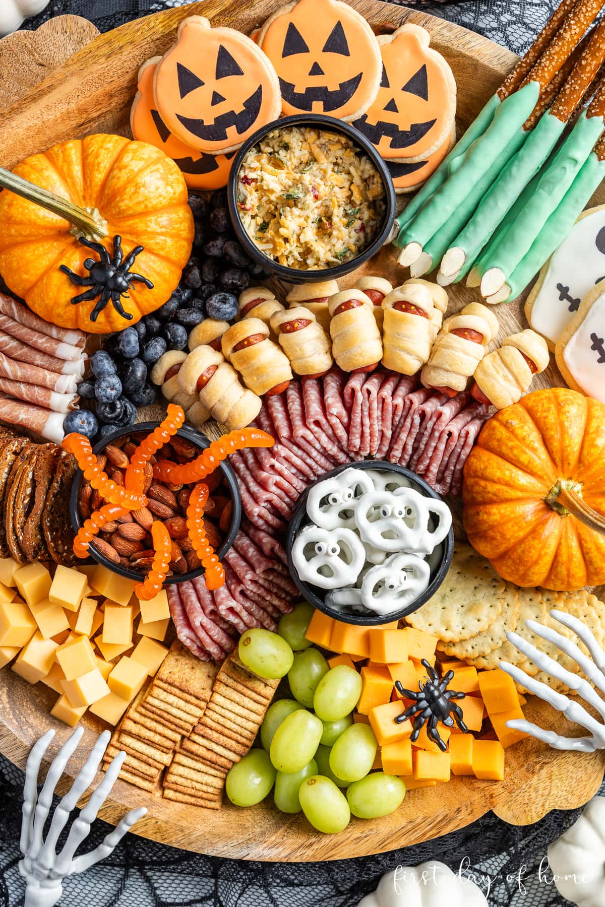 Halloween charcuterie board filled with a variety of cured meats, cheese cubes, crackers, and other sweet and savory treats. 