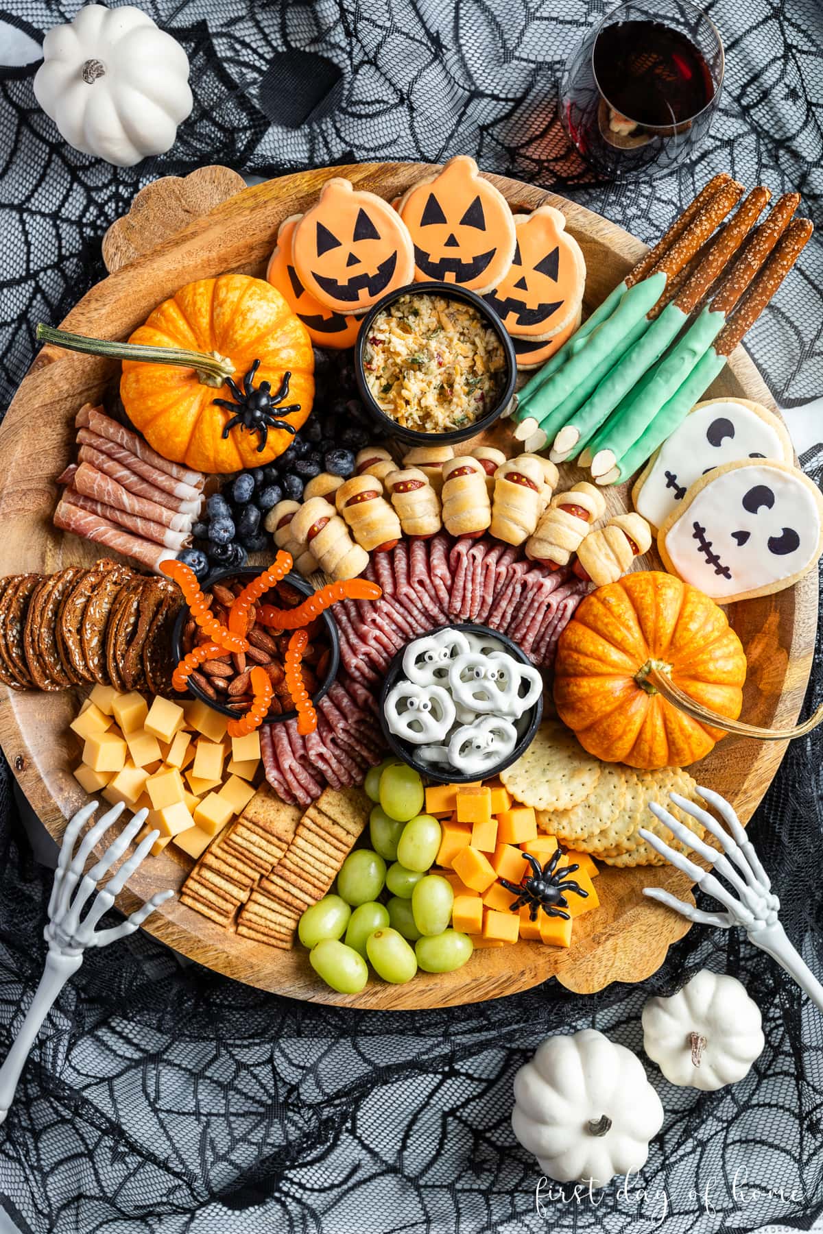 Halloween themed charcuterie board with mix of deli meats, cheeses, crackers, fruit, nuts, cookies, and other snacks.