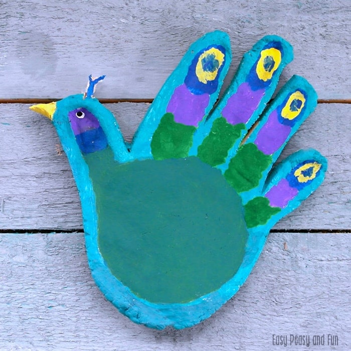 Salt dough peacock using the shape of a child's hand for the features and head.