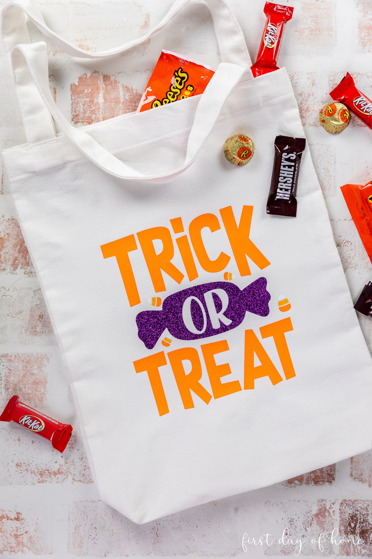DIY trick or treat bag using glitter iron-on vinyl and everyday iron-on vinyl, shown with Halloween candy.