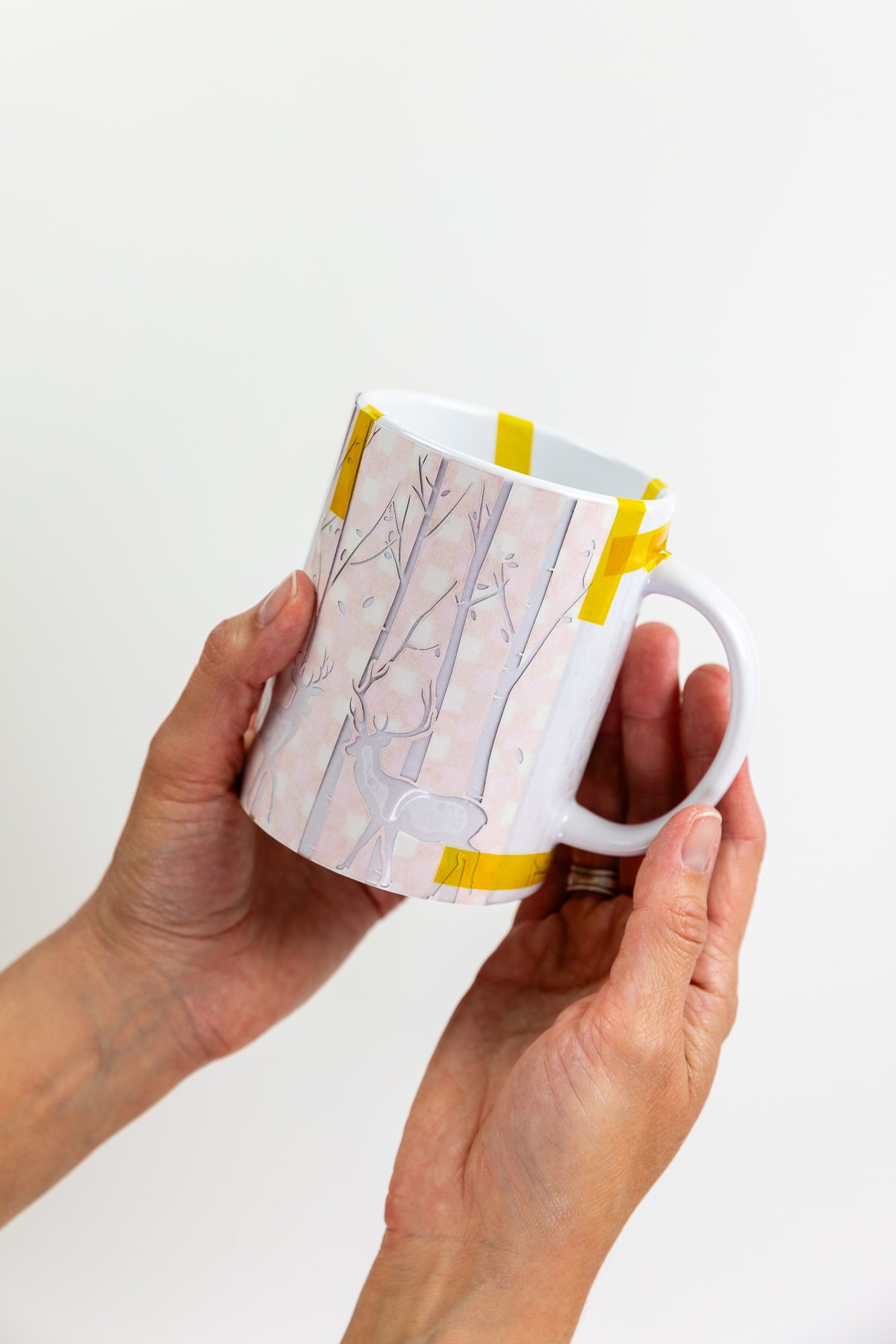 Infusible ink transfer sheet wrapped around mug with heat resistant tape.