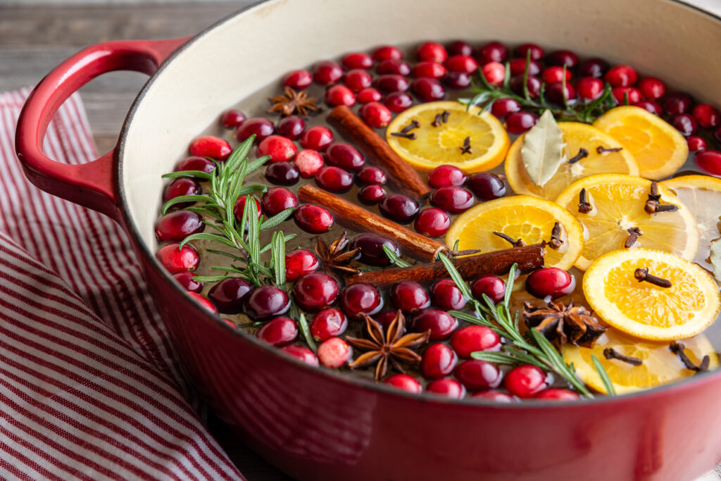 Simmer pot filled with cranberries, rosemary, star anise, cinnamon sticks, orange slices, and cloves.