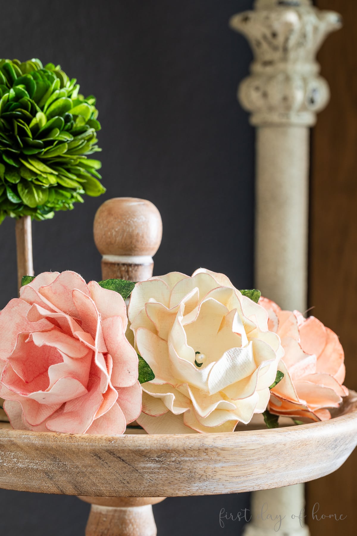 Trio of paper roses sitting on a tiered tray.