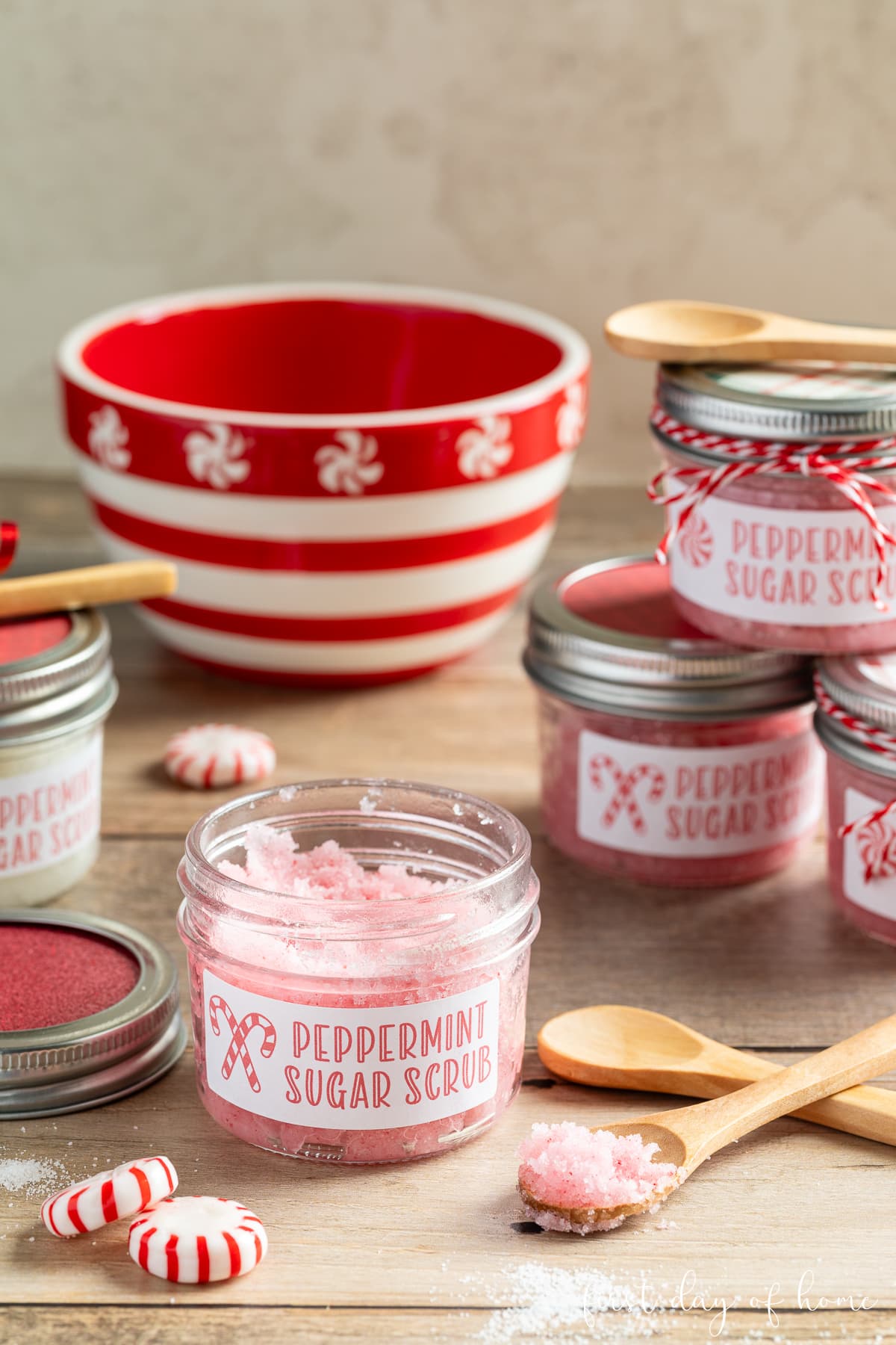 Peppermint sugar scrub in mason jars with wooden spoons.