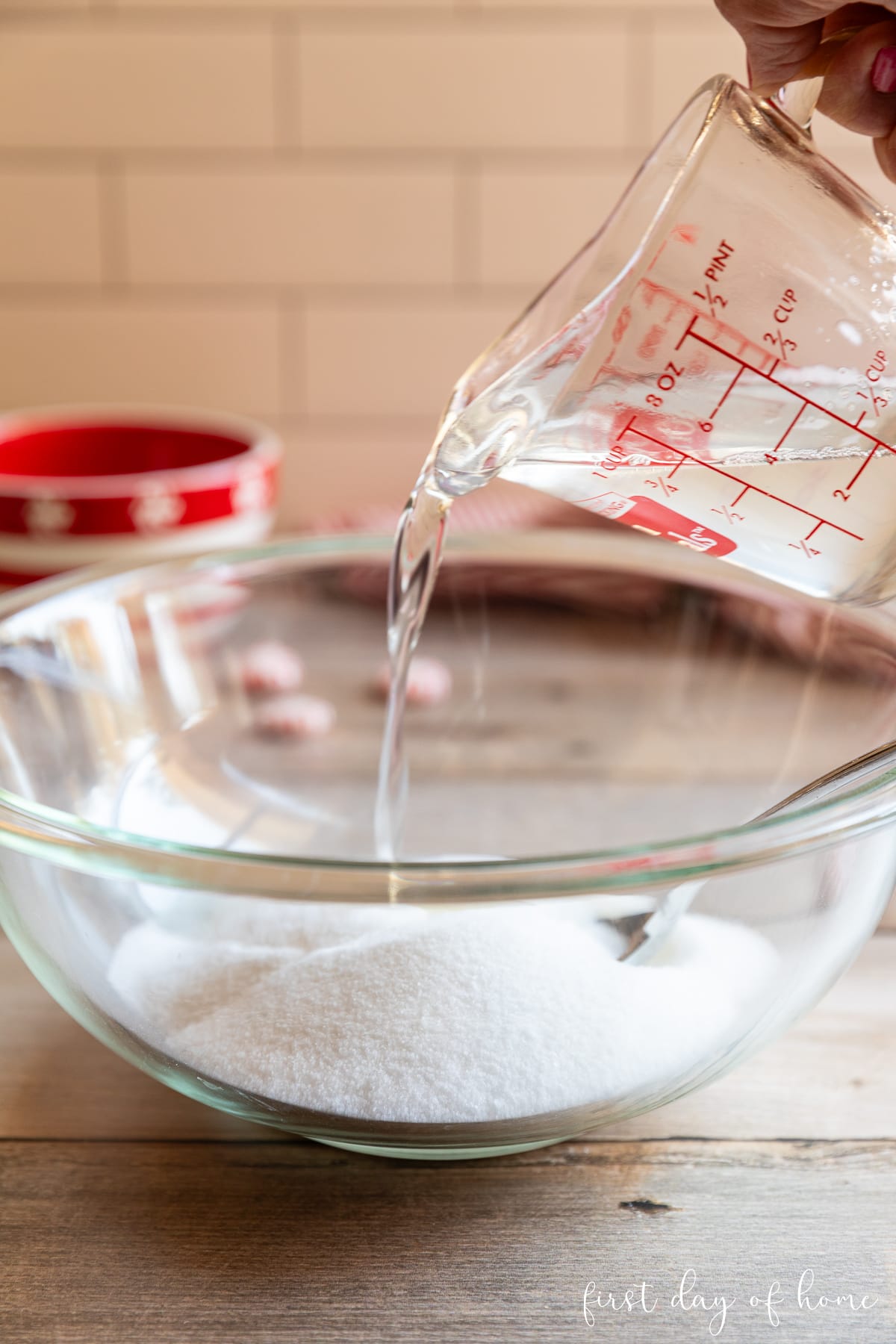 Blending coconut oil with sugar in a glass mixing bowl.