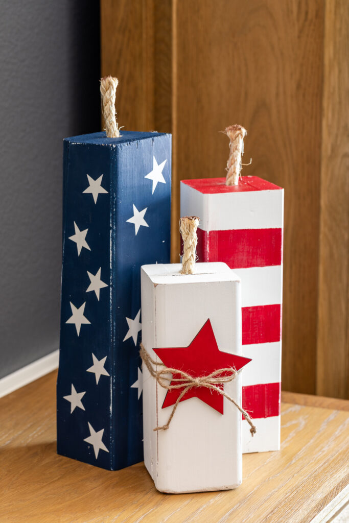 Trio of wooden fireworks decorations with stars and stripes in the colors of the U.S. flag.