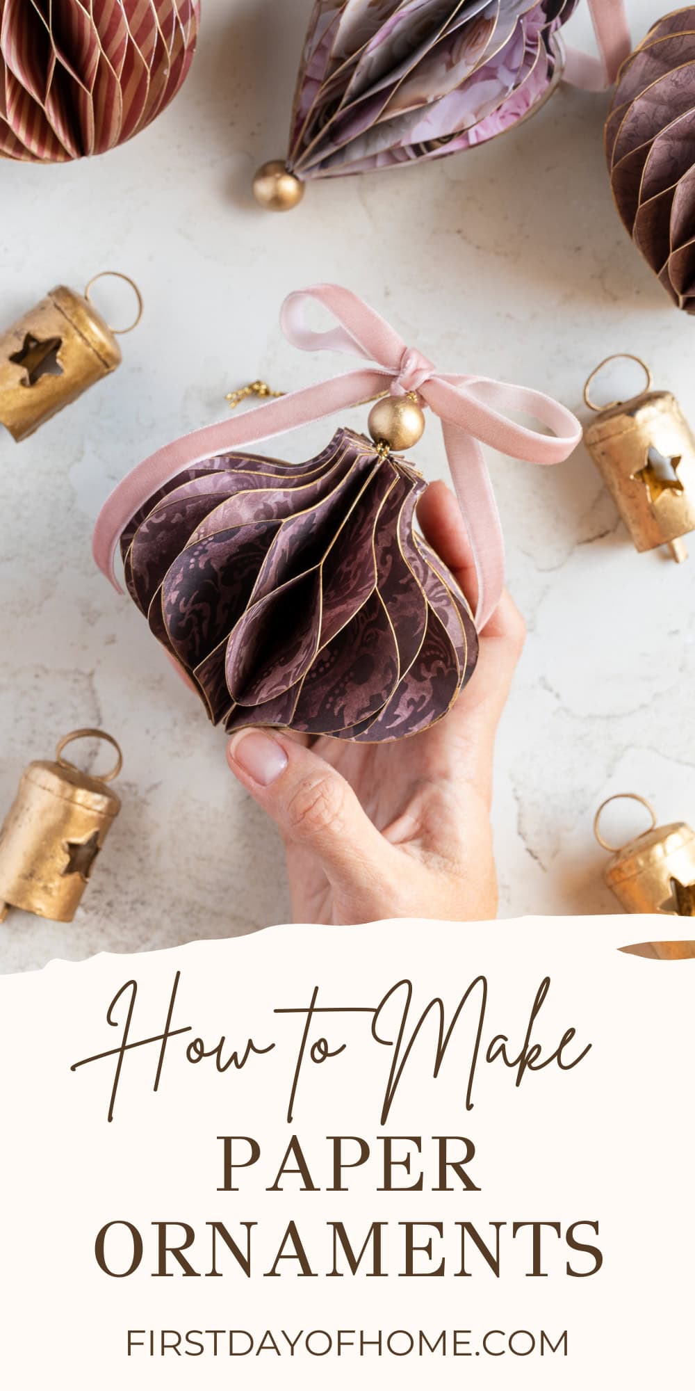 Hand holding a honeycomb paper Christmas ornament.
