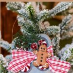 Mini muffin tin ornament with a gingerbread man hanging on a small Christmas tree.