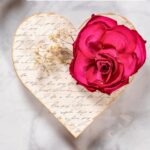 Decoupage heart with patterned paper background and dried flowers.