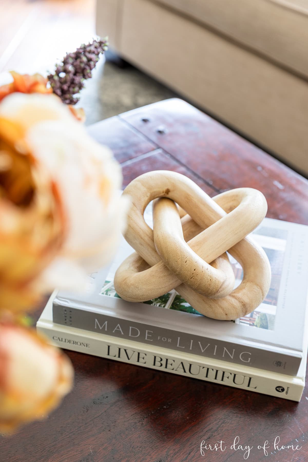 Wooden knot on stack of coffee table books.