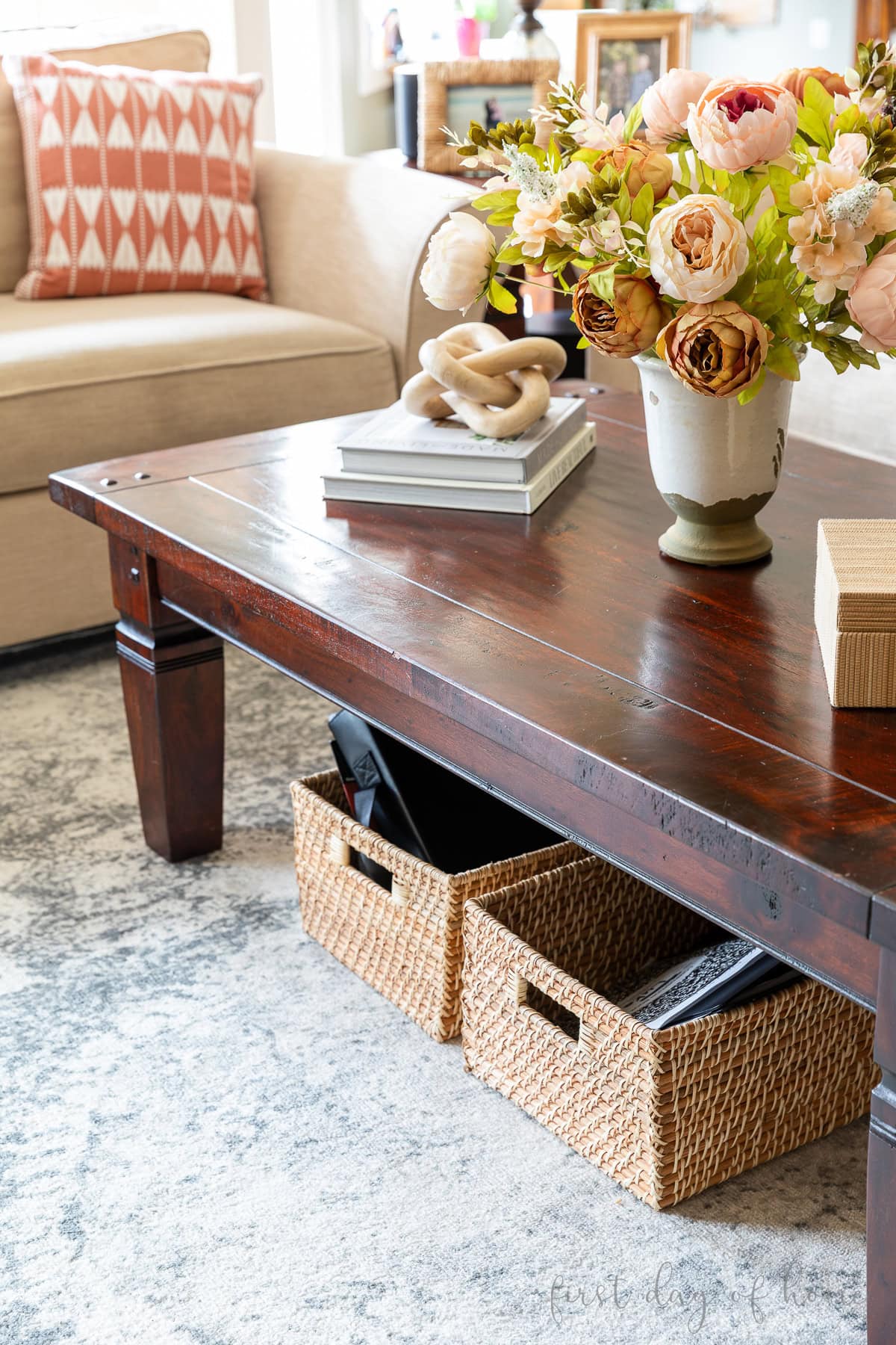 Baskets under a coffee table in a living room holding papers.
