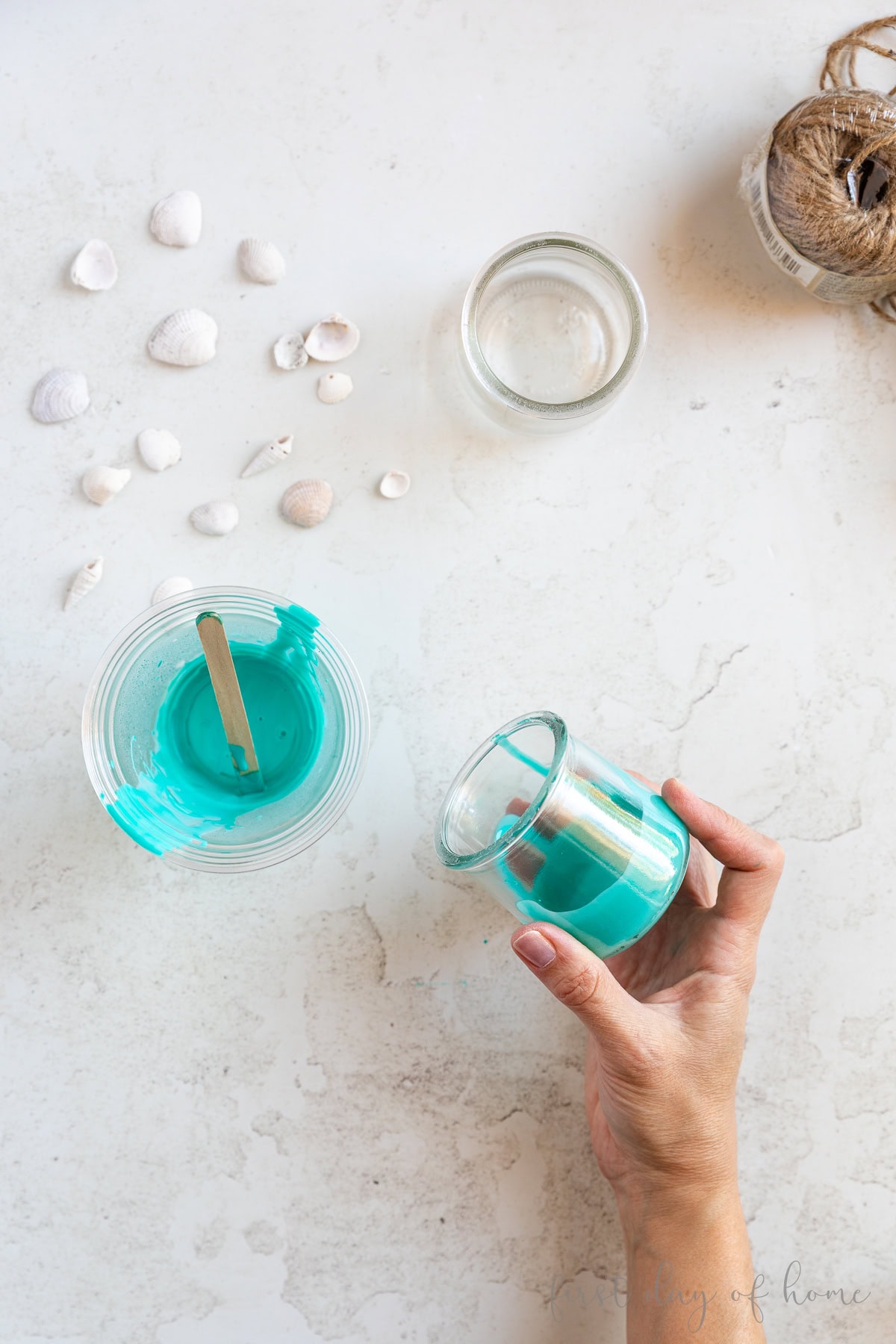 Spreading Mod Podge and food coloring in glass jar.