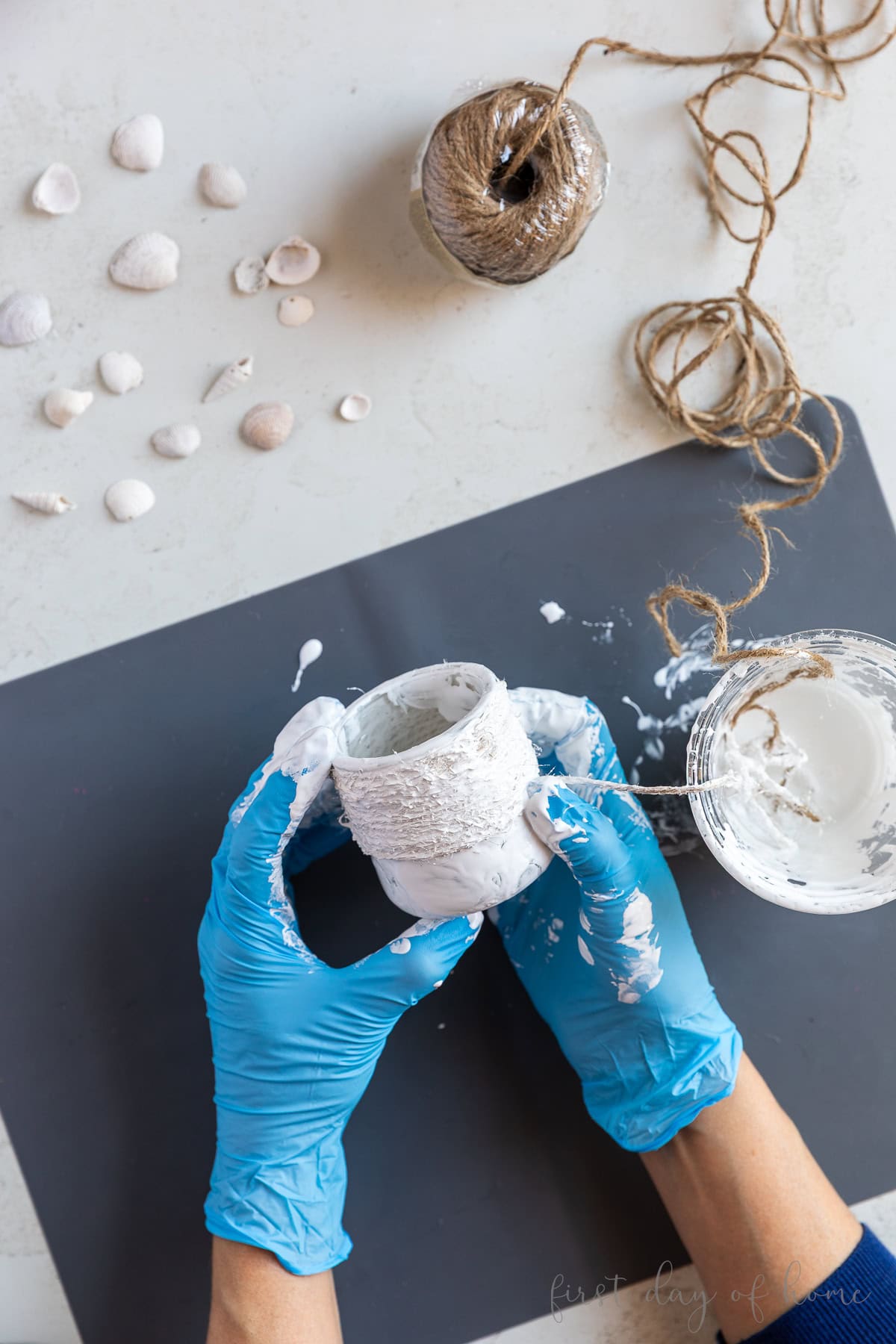 Wrapping jute twine around a glass jar with Mod Podge Texture Coat.