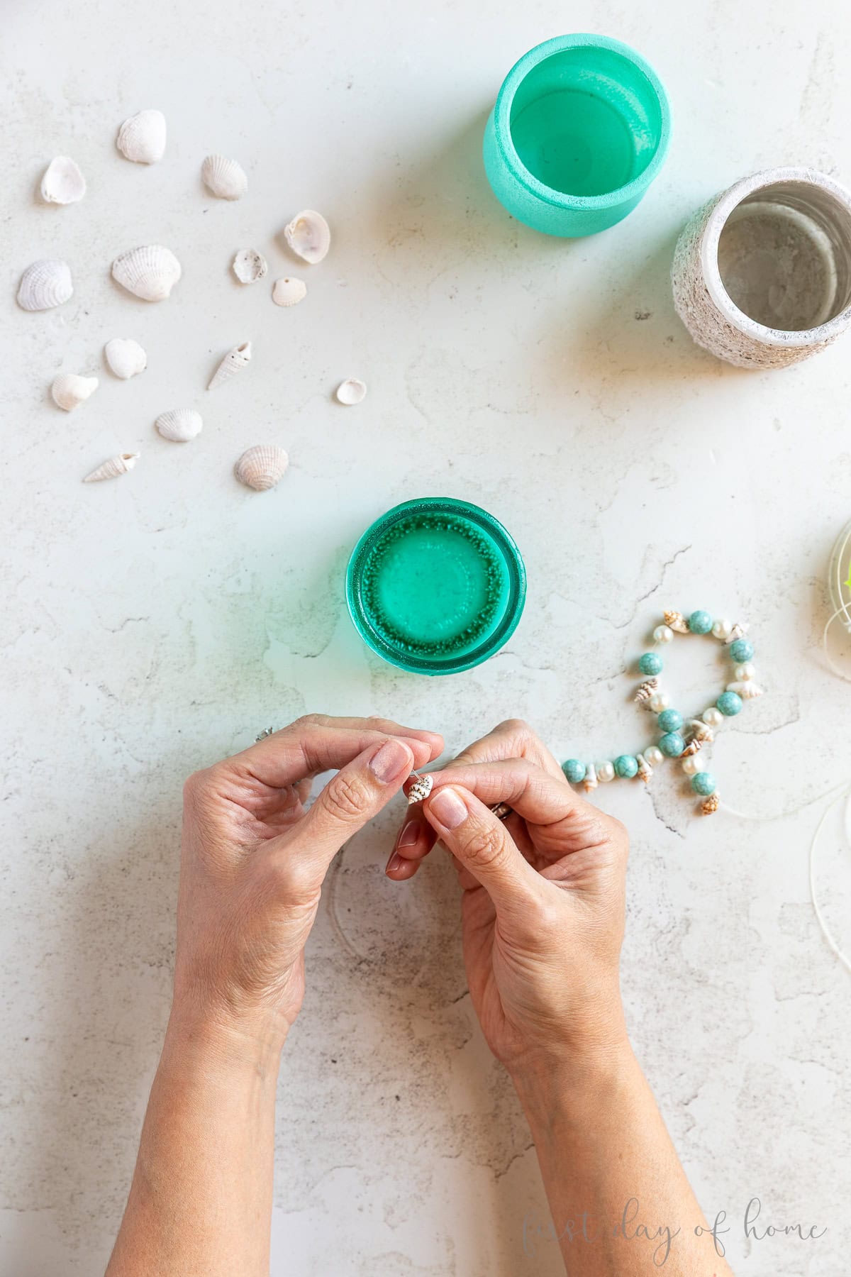Adding shell beads and round beads to Oui yogurt glass jar.